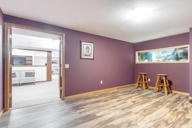 interior space featuring baseboards and wood finished floors