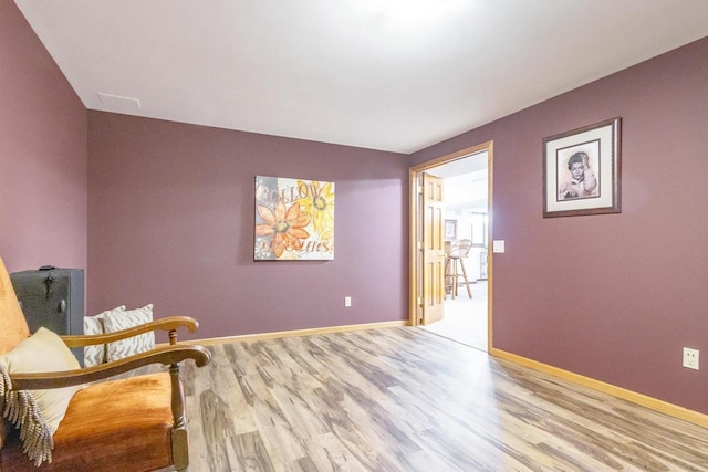 living area featuring baseboards and wood finished floors