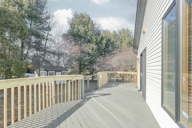 wooden terrace featuring a storage unit and an outdoor structure