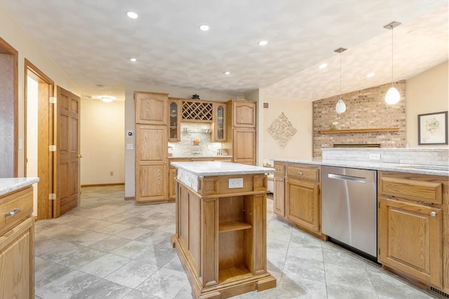 kitchen with light stone counters, glass insert cabinets, stainless steel dishwasher, tasteful backsplash, and a center island