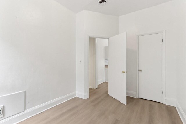 unfurnished bedroom featuring visible vents, light wood-style flooring, and baseboards