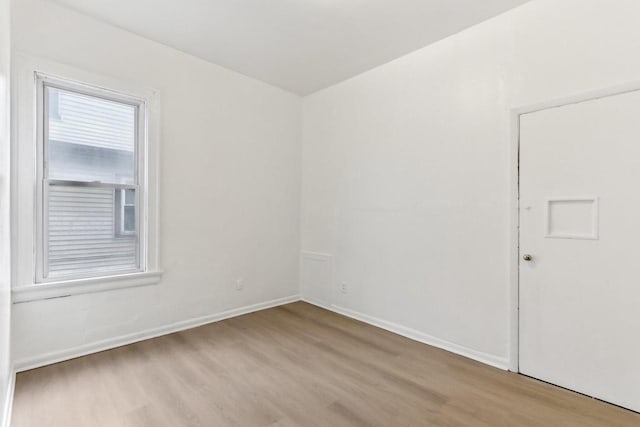 spare room featuring baseboards and wood finished floors