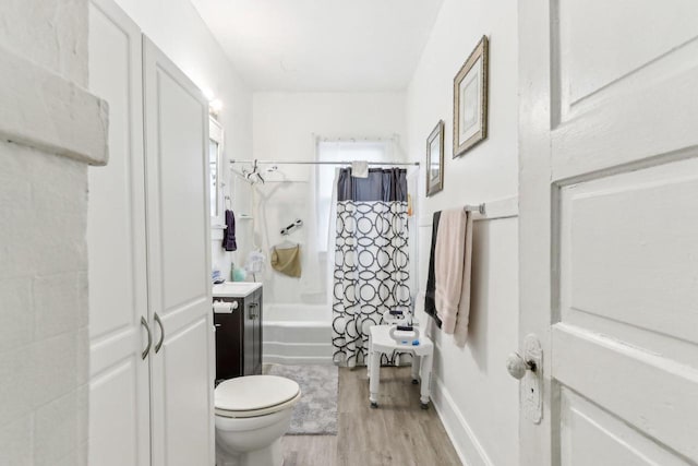 bathroom featuring vanity, toilet, wood finished floors, and shower / bath combo with shower curtain