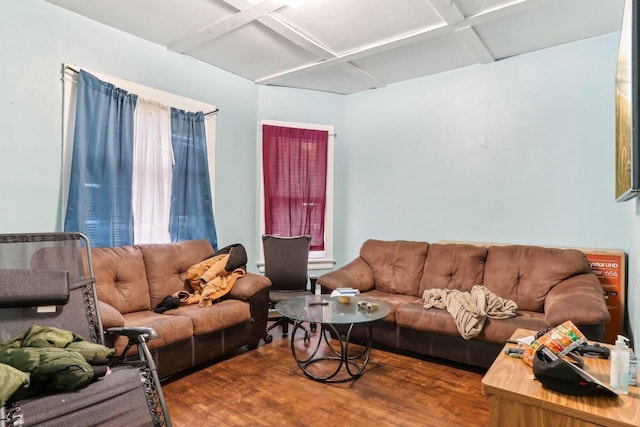 living area featuring coffered ceiling and wood finished floors