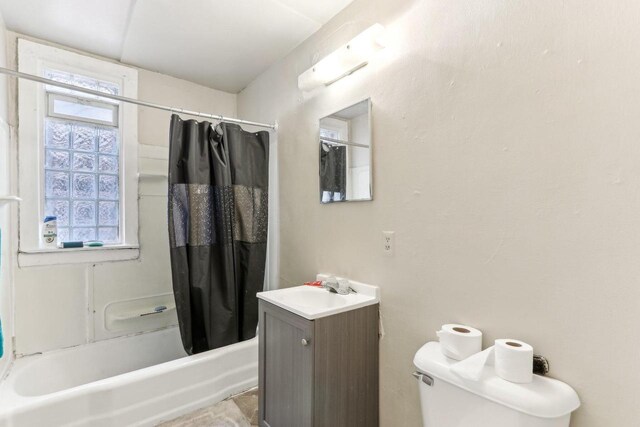 bathroom featuring plenty of natural light, toilet, vanity, and shower / bath combo