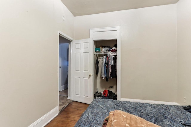 bedroom featuring a closet, baseboards, and wood finished floors