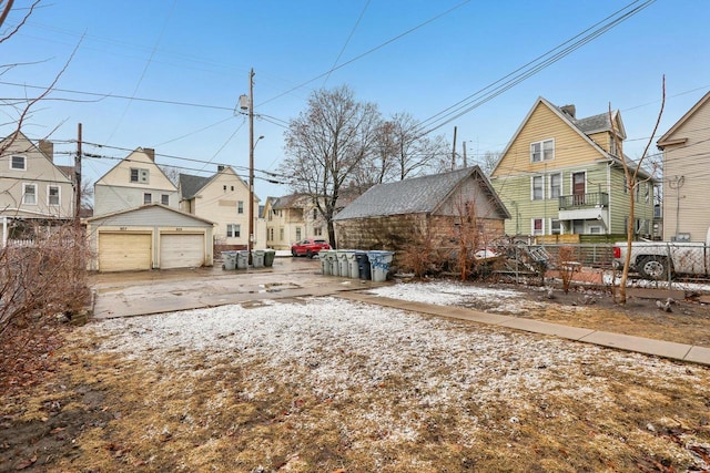 view of yard with an outbuilding, a residential view, a garage, and fence