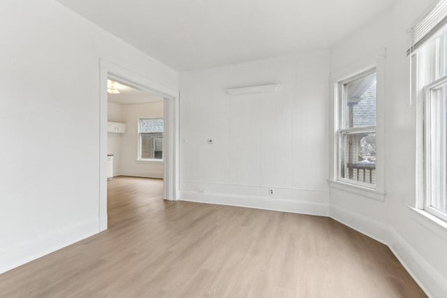 empty room featuring light wood finished floors and baseboards