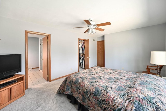 bedroom featuring visible vents, a ceiling fan, baseboards, light colored carpet, and a spacious closet