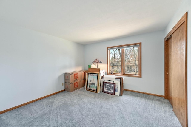 interior space with light carpet and baseboards