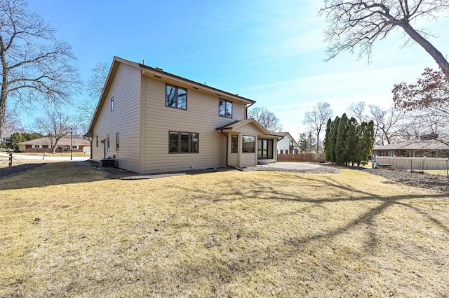 rear view of house with a patio area, central AC unit, a yard, and fence