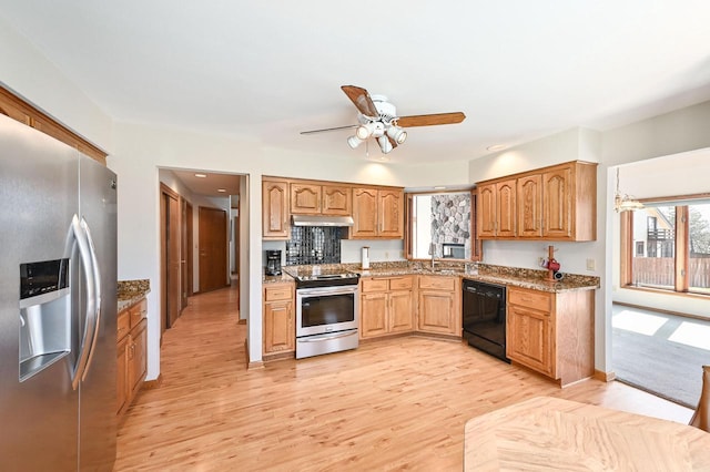 kitchen with ceiling fan, under cabinet range hood, light wood-type flooring, stone counters, and appliances with stainless steel finishes