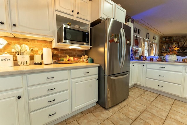 kitchen featuring decorative backsplash, light countertops, light tile patterned floors, and stainless steel appliances