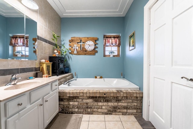 bathroom with tile patterned floors, a garden tub, and vanity