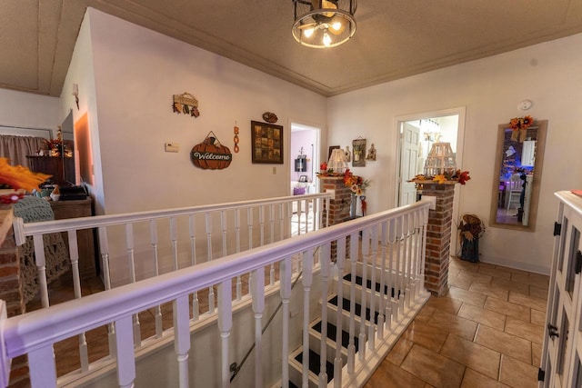 corridor with baseboards, an upstairs landing, and crown molding