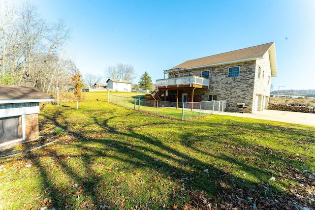 view of yard featuring concrete driveway, an attached garage, fence, and a wooden deck