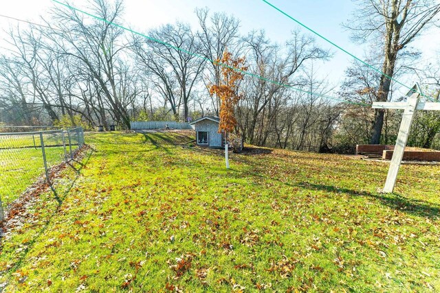 view of yard with a storage unit, an outdoor structure, and fence