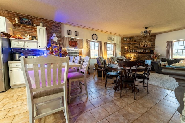 dining room with a textured ceiling, a fireplace, and crown molding