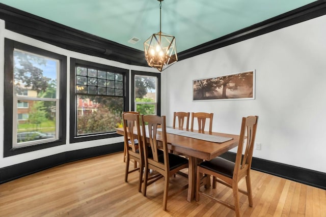 dining area featuring a notable chandelier, baseboards, crown molding, and light wood-style floors