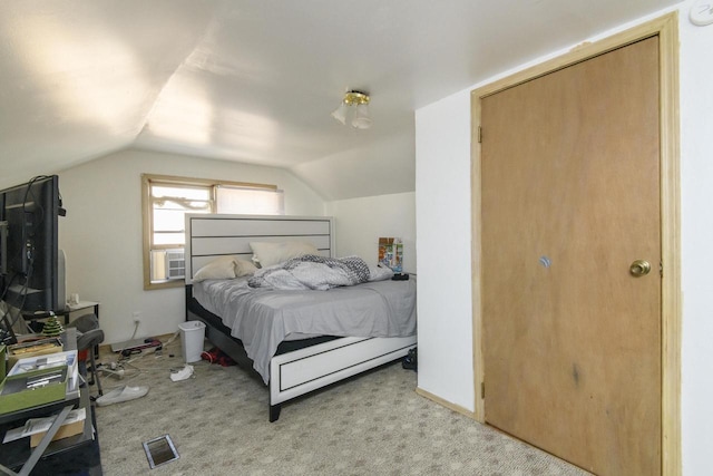 bedroom featuring lofted ceiling, visible vents, and light carpet