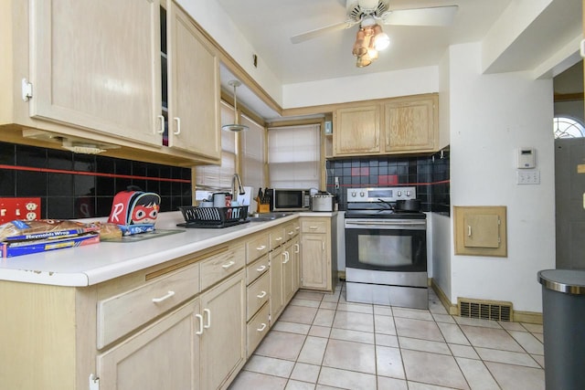 kitchen with visible vents, light brown cabinets, appliances with stainless steel finishes, light tile patterned flooring, and a sink