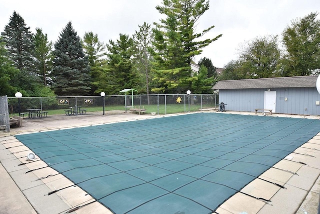 view of swimming pool with a fenced in pool, an outdoor structure, a patio, and fence