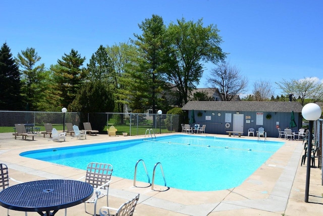 pool with a patio and fence