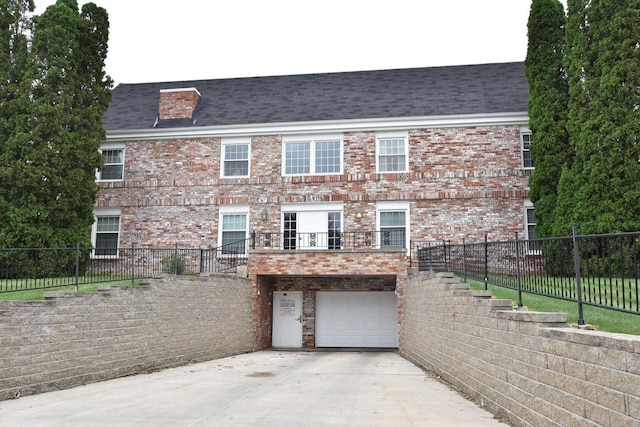 view of front of house featuring brick siding, concrete driveway, an attached garage, and fence