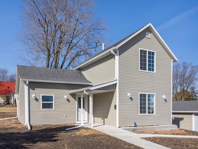 traditional-style home featuring roof with shingles