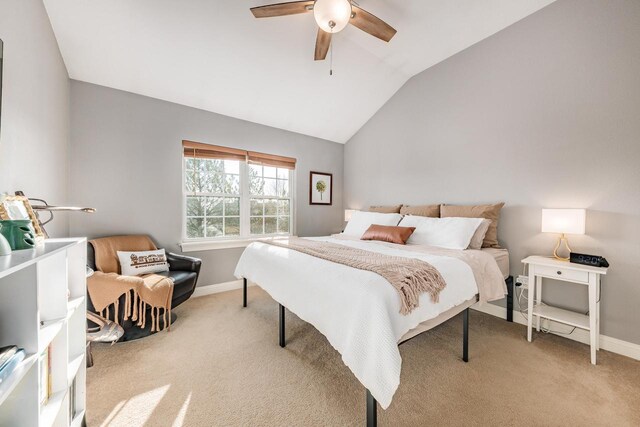 bedroom with lofted ceiling, light colored carpet, baseboards, and ceiling fan