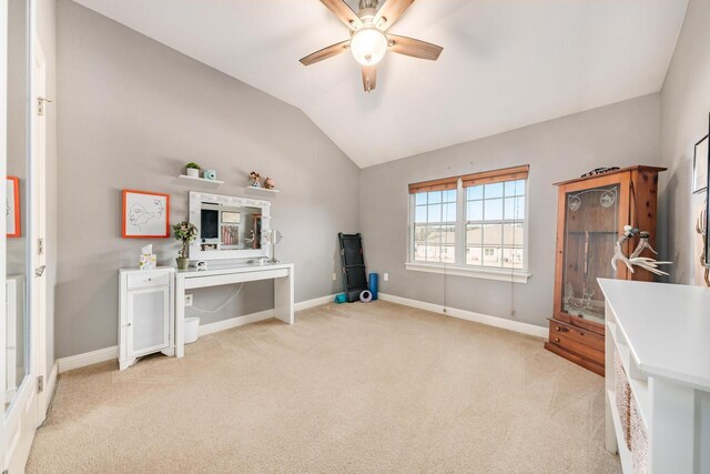 interior space with light carpet, a ceiling fan, baseboards, and vaulted ceiling