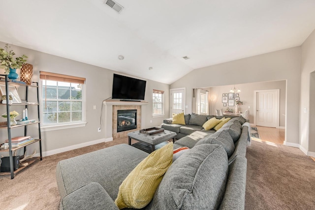 carpeted living area with visible vents, lofted ceiling, baseboards, and a fireplace