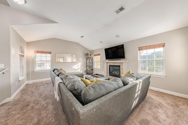 carpeted living room featuring lofted ceiling, plenty of natural light, a fireplace, and visible vents