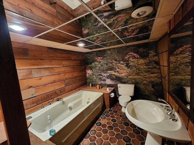 bathroom featuring toilet, a whirlpool tub, and a sink