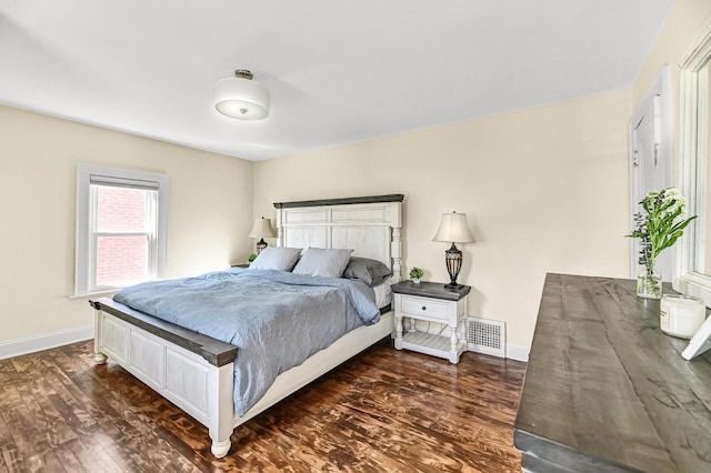 bedroom with dark wood finished floors and baseboards