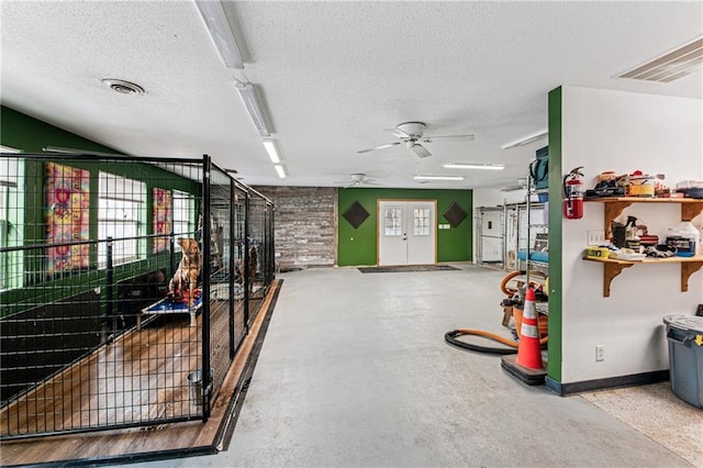 garage with visible vents, french doors, a ceiling fan, and baseboards