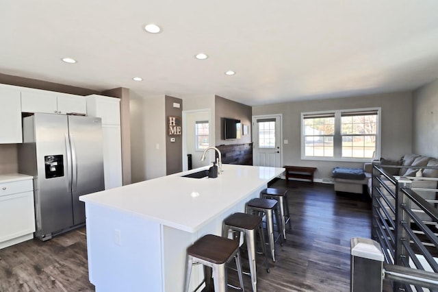 kitchen with a sink, plenty of natural light, open floor plan, and stainless steel fridge with ice dispenser