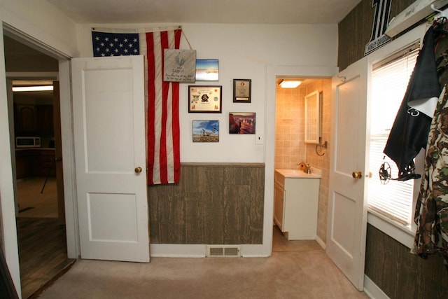 bathroom with vanity, visible vents, a healthy amount of sunlight, and a wainscoted wall