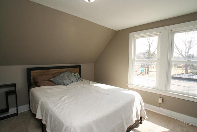 bedroom with carpet flooring, baseboards, and vaulted ceiling