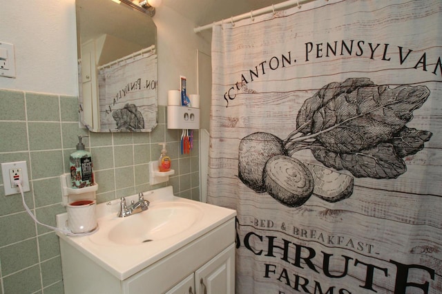 full bathroom featuring vanity, tile walls, and curtained shower