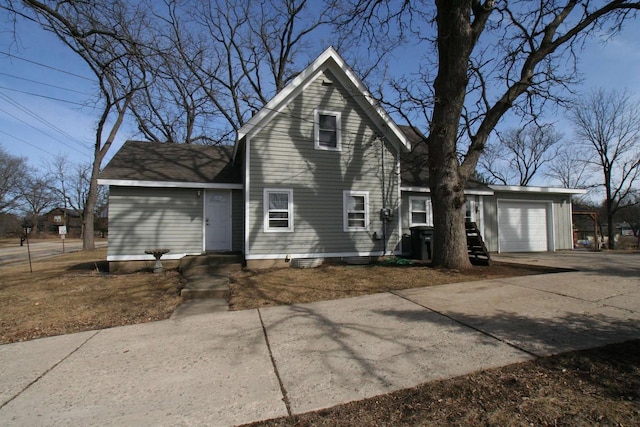 view of front facade with concrete driveway, a garage, and roof with shingles