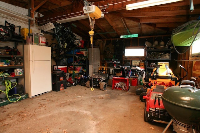 garage featuring a garage door opener and freestanding refrigerator