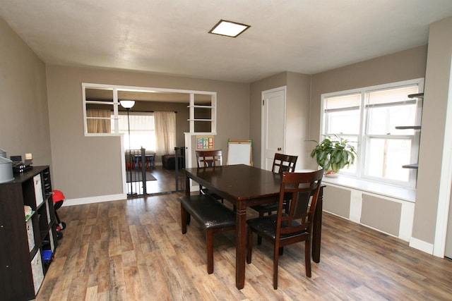 dining space featuring baseboards and wood finished floors