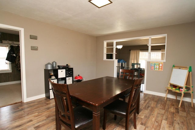 dining area featuring a wealth of natural light, baseboards, and wood finished floors