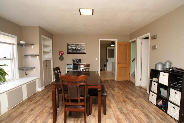 dining area featuring stairs and light wood-style floors