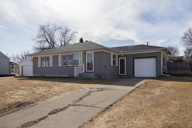 ranch-style home with entry steps, concrete driveway, an attached garage, a shingled roof, and a chimney