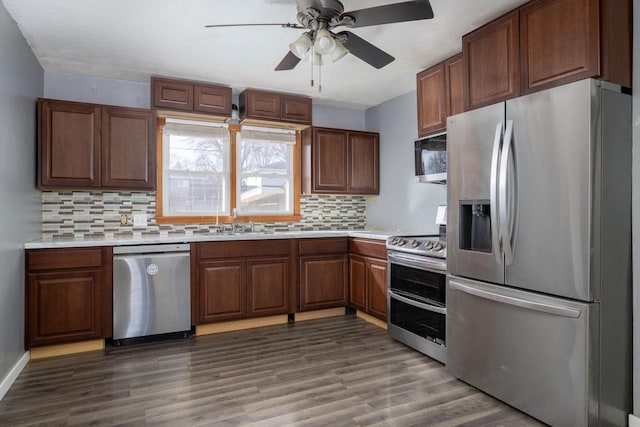 kitchen featuring decorative backsplash, appliances with stainless steel finishes, light countertops, and dark wood-type flooring