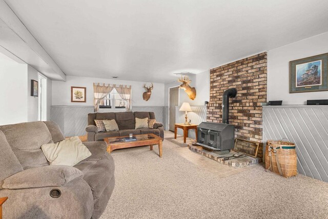 living room with a wainscoted wall and a wood stove