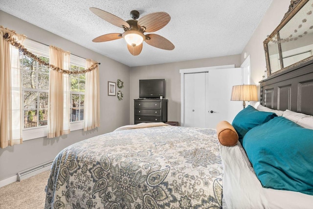 carpeted bedroom featuring baseboards, a baseboard radiator, ceiling fan, a closet, and a textured ceiling