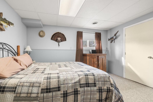 bedroom with visible vents, a drop ceiling, and carpet floors